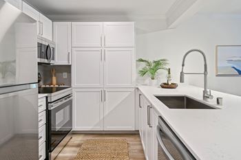 A kitchen with white cabinets and a stainless steel sink. at Lakemont Orchard Apartments, Issaquah , WA